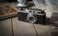 Vintage analogue film camera on a wooden table, map, notepad, pencil. Royalty Free Stock Photo