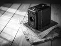 Vintage analogue film camera on a wooden table, old book, clothl. Black and white photo. Copy space