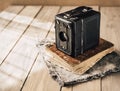 Vintage analogue film camera on a wooden table, old book, clothl. Retro photo. Copy space.
