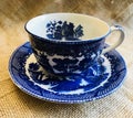 Vintage Antique Blue Willow Ware Teacup and Saucer on Burlap Background Royalty Free Stock Photo