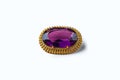 Vintage antique brooch with a large semi-precious purple stone on white background. Oldfashioned decoration from grandma`s jewelr