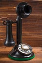 Vintage, antique candlestick telephone with dial on wood background Royalty Free Stock Photo