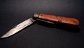 vintage antique swiss military pocket knife with used and rusty blade from the second world war black background