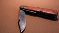 vintage antique swiss military pocket knife with used and rusty second world war blade brown background