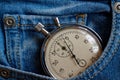 Vintage antiques Stopwatch, in old worn dark blue denim pocket, value measure time, old clock arrow minute, second accuracy timer Royalty Free Stock Photo