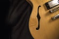 Vintage archtop guitar in natural maple close-up from above on black background, F-hole detail Royalty Free Stock Photo
