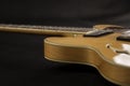 Vintage archtop guitar in natural maple close-up high angle side view in selective focus on black background Royalty Free Stock Photo