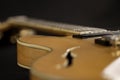 Vintage archtop guitar in natural maple close-up high angle view on black background, pick-up side in selective focus Royalty Free Stock Photo