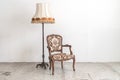 Vintage armchair and lamp on white wall. Royalty Free Stock Photo