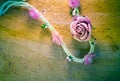 Vintage of artificial flowers rose on the old paper stripes.