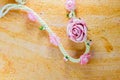 Vintage of artificial flowers rose on the old paper stripes.