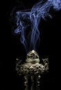 Vintage asian style iron vase on a black background with reflection and nice smoke Royalty Free Stock Photo