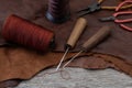 Awl with wooden handle and nylon thread placed on leather and old wooden floors. Royalty Free Stock Photo