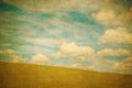 Vintage background of green field and blue cloudy sky Royalty Free Stock Photo