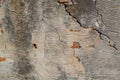 Vintage background texture. Old masonry stone bricks on the ancient cement with cracks. Old wall with cracks and peeling plaster.