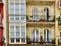 Vintage balconies with elegant doors with shutters on colourful elegant facade downtown Bilbao, Basque Country, Spain