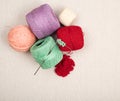 Vintage balls of knitting or crocheting thin cotton yarn in a variety of colors on off white linen background for copy space. It