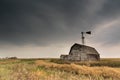 Vintage barn, bins and windmill under ominous dark skies in Saskatchewan, Canada Royalty Free Stock Photo