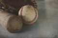 Vintage baseball bat and old ball, with leather glove in background. Royalty Free Stock Photo