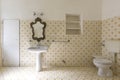 Vintage bathroom in ancient villa with tiles, sink, antique mirror and toilet Royalty Free Stock Photo