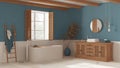 Vintage bathroom in white and blue tones, rattan wooden washbasin, bathtub, chest of drawers, mirror, towel rack and decors.