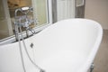 Vintage bathtub with faucet and shower in bathroom Royalty Free Stock Photo