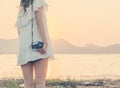 Vintage of beautiful women photography standing hand holding retro camera with sunrise,dream soft style Royalty Free Stock Photo