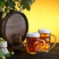 Vintage beer barrel with two beer glasses and frame of fresh hops Royalty Free Stock Photo