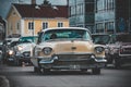 Vintage beige car during a cruising event on a city road