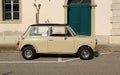 Vintage beige Mini Cooper of the Seventies at the roadside.