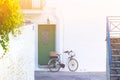 Vintage bicycle with basked, against white wall, in narrow street of a small Greek town Royalty Free Stock Photo