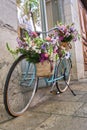 vintage bicycle decorated with wicker baskets hanging from the handlebars full of beautiful flowers, girona flower festival ,