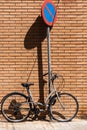 Vintage bicycle leaning against a traffic sign on an orange brick wall Royalty Free Stock Photo