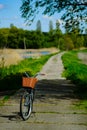 Vintage bicycle parking outdoor. Bike with rustic basket on the village road, summer scene