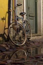 Vintage bike tied to the downpipe on cobbled street of old town Royalty Free Stock Photo