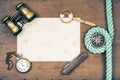 Vintage binoculars, compass, old paper, pocket watch, knife, rope, magnifying glass on wooden background Royalty Free Stock Photo