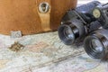 Vintage binoculars, leather case and compass resting on an old w Royalty Free Stock Photo