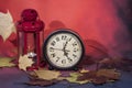 Vintage black alarm clock on autumn leaves. Time change abstract photo. Daylight saving time Royalty Free Stock Photo