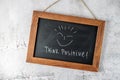 Vintage black board or school chalkboard with text Think positive hanging on stone wall Royalty Free Stock Photo