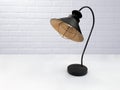 Vintage black lamp on the table against the background of the white loft. Royalty Free Stock Photo