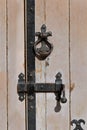 Vintage black metal latch and knob pull hande on old beige wooden door Royalty Free Stock Photo