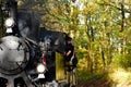 vintage black steam engine and kids miniature train riding through green forest. leisure, fun and outdoors concept