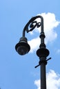 Vintage black street light in historic Savanah Georgia. Clear blue sky with bright white puffy cloud.