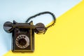 Vintage black telephone on yellow and blue Royalty Free Stock Photo