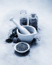 Black and white mortar and pestle with spices and herbs on canvas table cloth Royalty Free Stock Photo