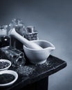 Old black and white mortar and pestle with herbs and spices on wood table Royalty Free Stock Photo