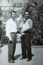 Vintage black and white photo of brothers holding a child, family, 1950s European.