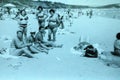 Vintage black and white photo of people on a beach enjoying the sun, 1950s European.