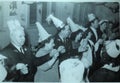 Vintage black and white photo of people at a party dancing and wearing funny hat, Christmas Party? 1950s European.