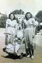 Vintage black and white photo of sisters with a child in pram, family, 1950s European.